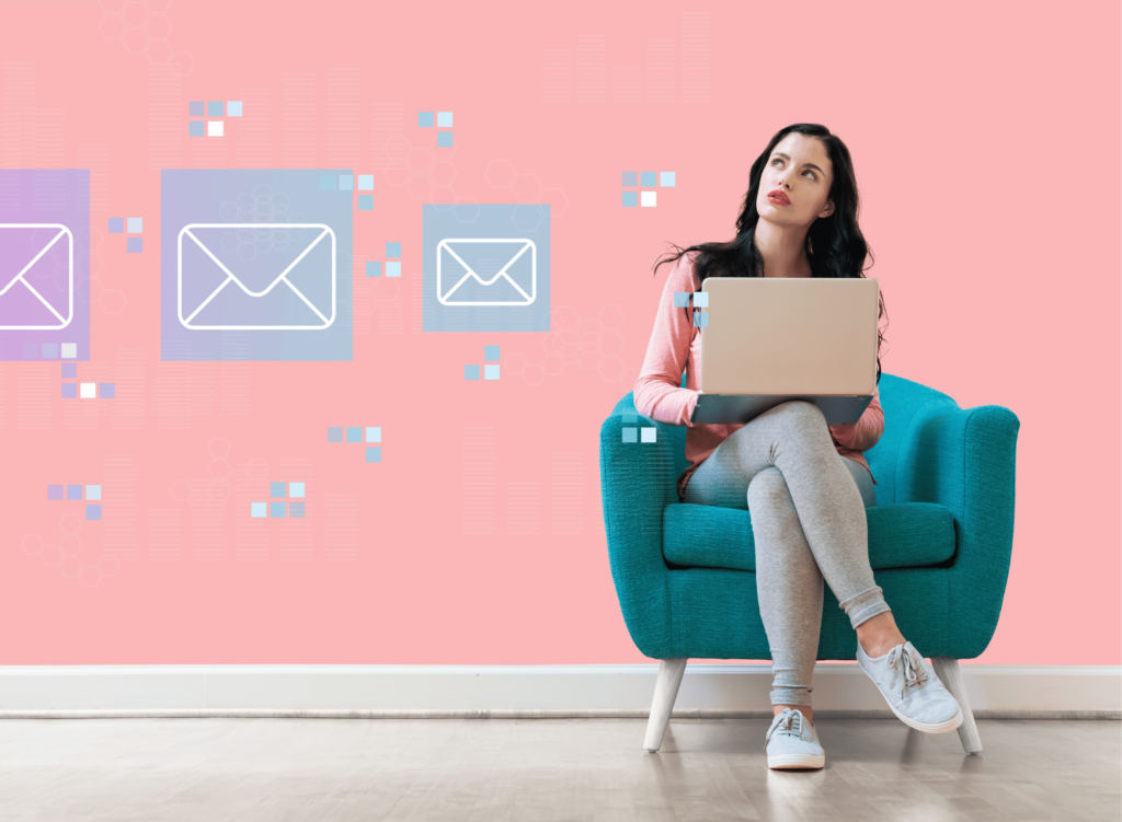 Email icons on a wall with a curious thinking woman sitting on a chair with a laptop
