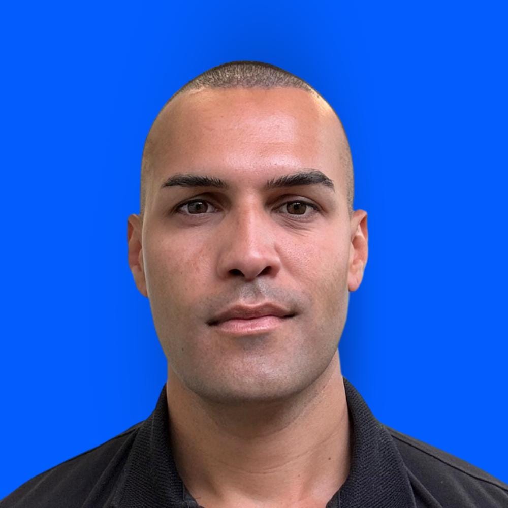 Dan Till director of Evolve Digital smiling in portrait photo with blue background